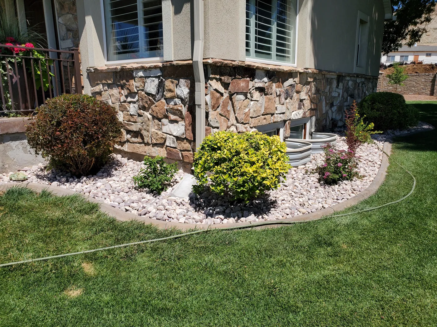 Manicured shrubs and crisp edging in a finished SLC landscaping job